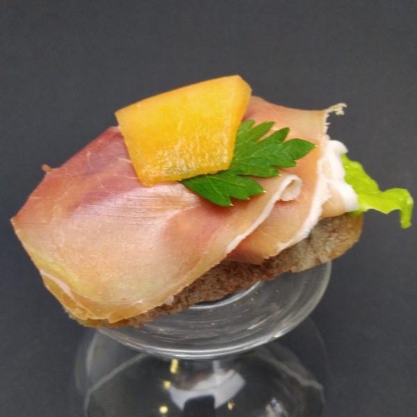 Cocktail-Canapés mit Serranoschinken und Honigmelone, hochwertig dekoriert